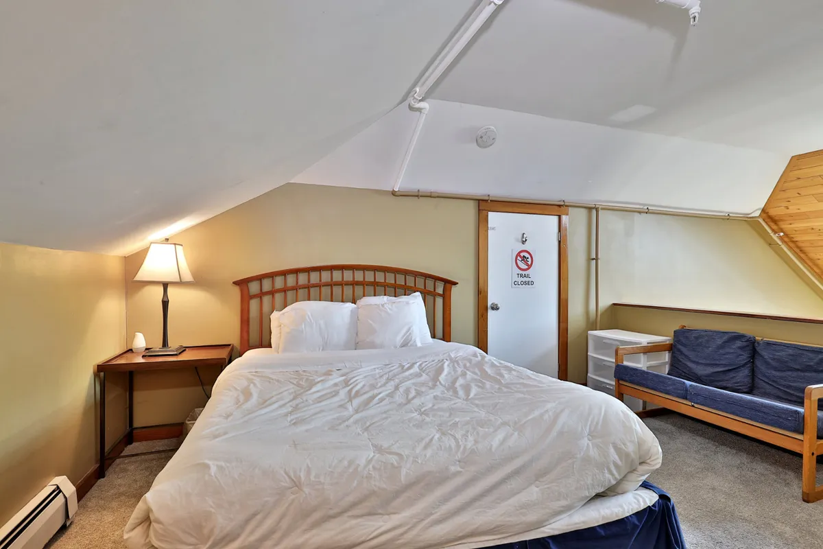 A multi-functional space with a bed, lamp, sofa, and door, offering options for resting, reading, or socializing. The relaxed mood suggests versatility, much like the loft or sleeper sofa areas described in the section.